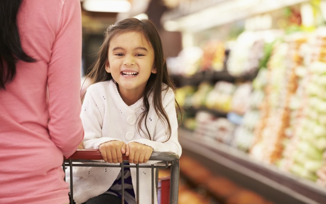 Young girl shopping with mom for healthy items