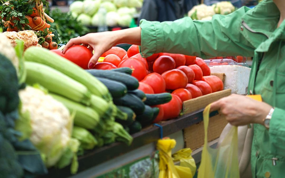 Senior woman using her benefits at a produce market.