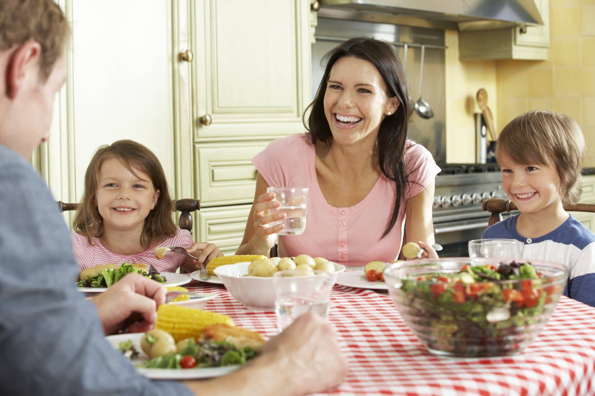 A happy family sharing a meal in the kitchen Solutran team member designing innovative healthcare solutions.