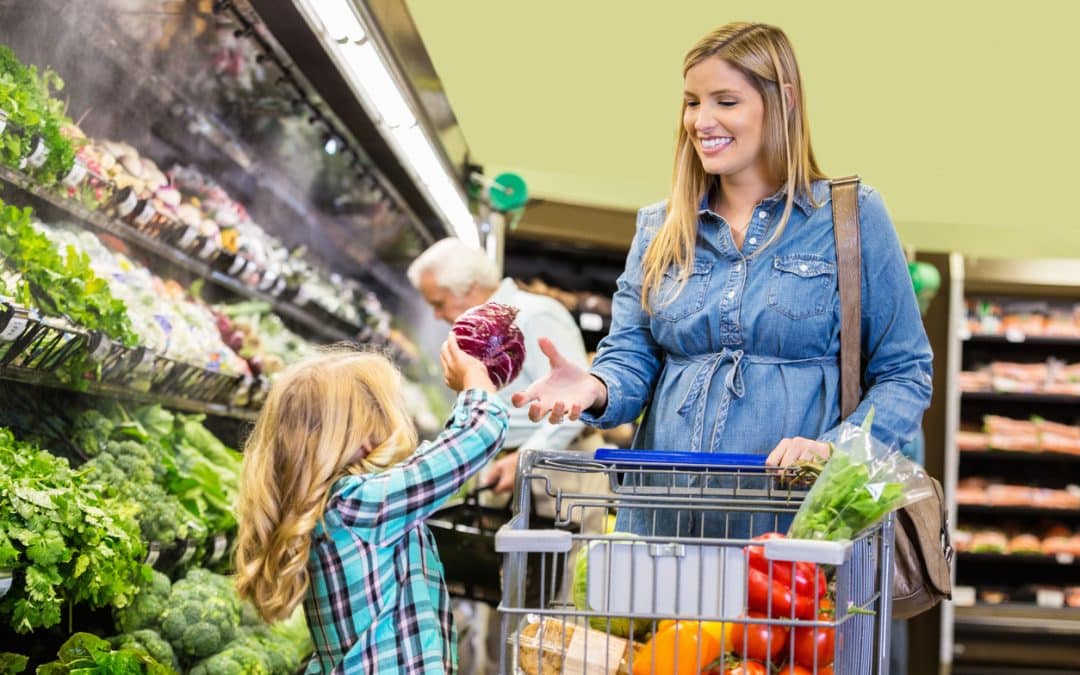 Mother and children shopping for healthy produce in grocery store