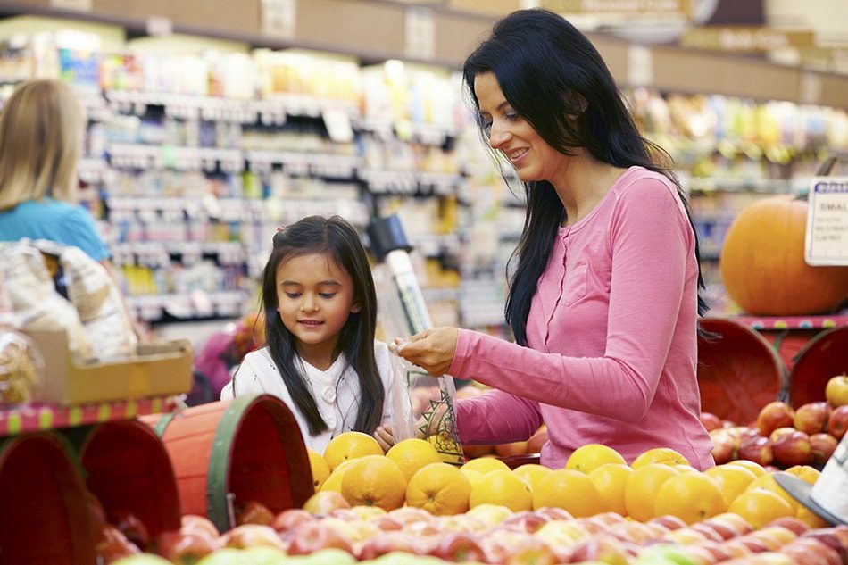 Mother and daughter shopping for healthy produce.